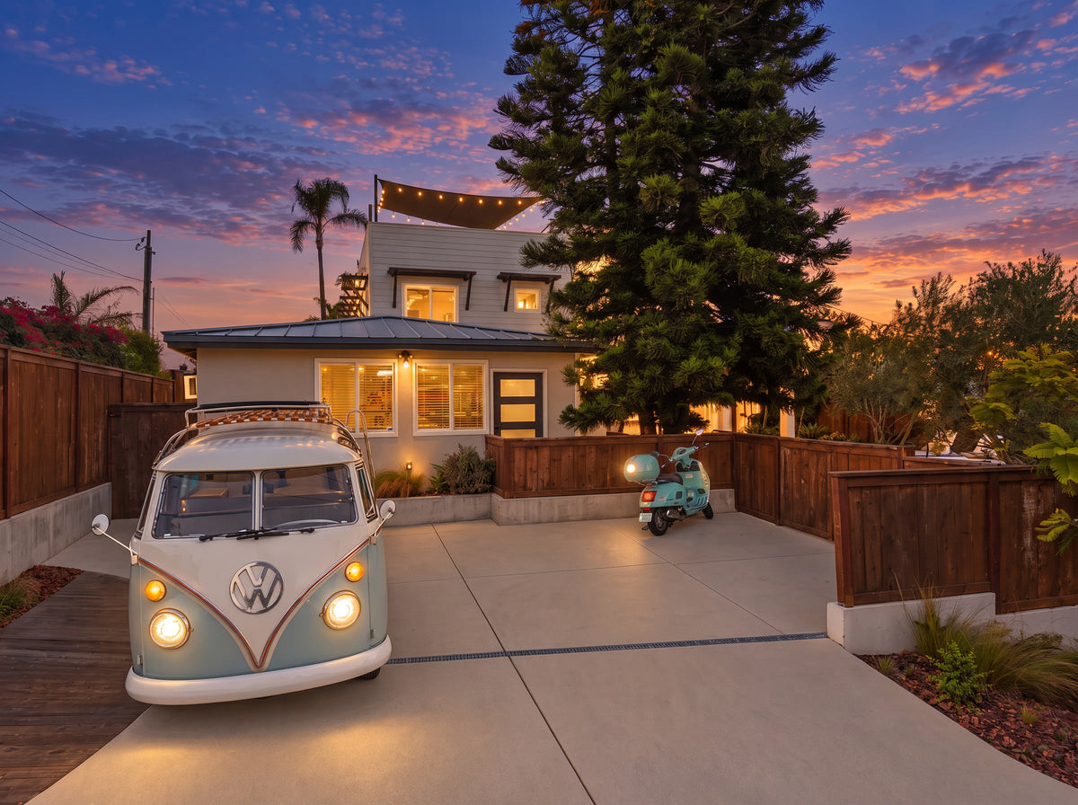 Koru Clips hold string lights along a shade sail above a house at sunset, with a vintage Volkswagen van and scooter in the foreground.